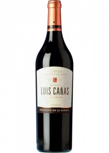 Botella de vino tinto, con cápsula de color naranja, cuerpo de botella color negro. La etiqueta en la botella es de color blanco, escrito Selección de la Familia 2019. Denominación de origen en Rioja.