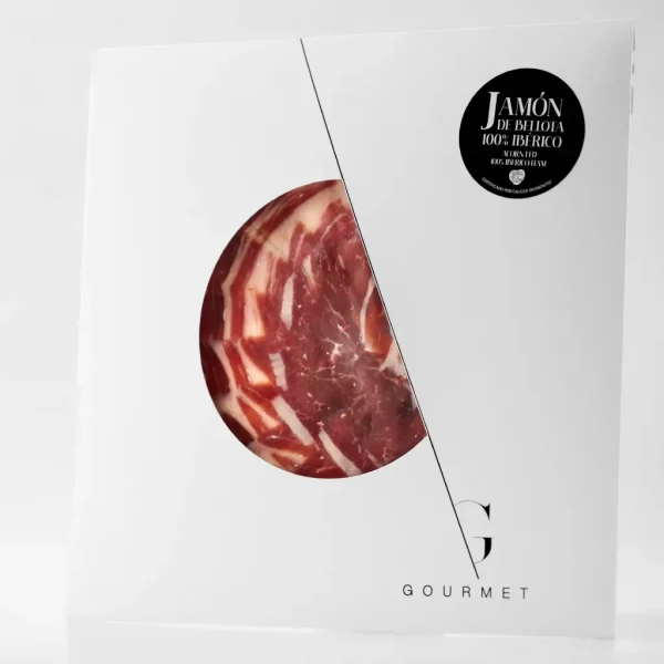 Guijuelo Gourmet Jamón de Bellota 100% Ibérico en un sobre blanco cuadrado, con una ventana circular en el centro que permite ver el jamón. En la esquina superior derecha, lleva una etiqueta negra.